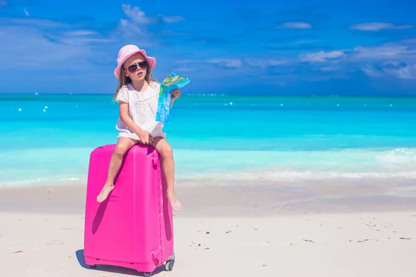 Little adorable girl with big suitcase on tropical beach — Stock Photo, Image