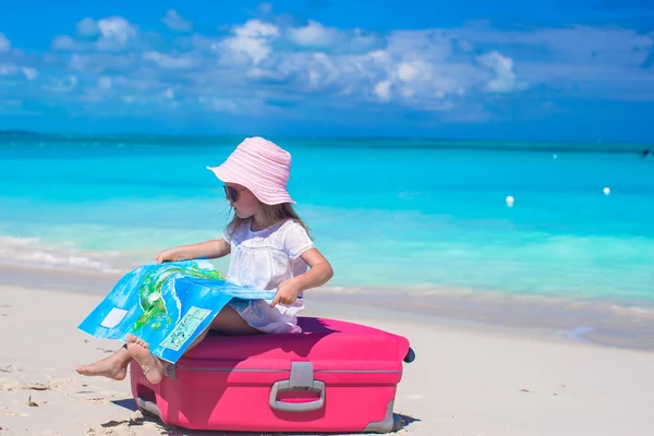 Little adorable girl with big suitcase on tropical beach — Stock Photo, Image