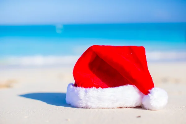 Close up Santa hat on a white sandy beach — Stock Photo, Image