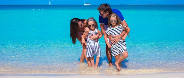 Семья из четырех человек с двумя детьми во время пляжного отдыха — стоковое фото