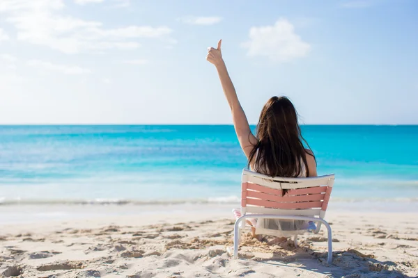 Mujer joven en silla de playa durante sus vacaciones tropicales —  Fotos de Stock