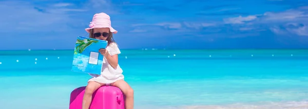 Little adorable girl with big suitcase on tropical beach — Stock Photo, Image