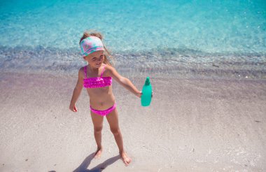 Güneş yanığı losyonu şişesi ile mayo küçük sevimli kız