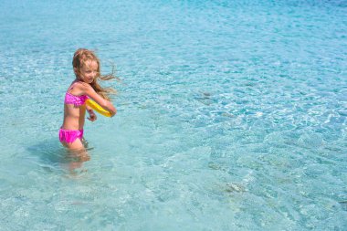 Küçük kız denizde sırasında tatil tropikal frizbi oynamaya