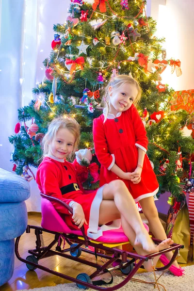 Meninas vestidas de Papai Noel perto da árvore de Natal — Fotografia de Stock