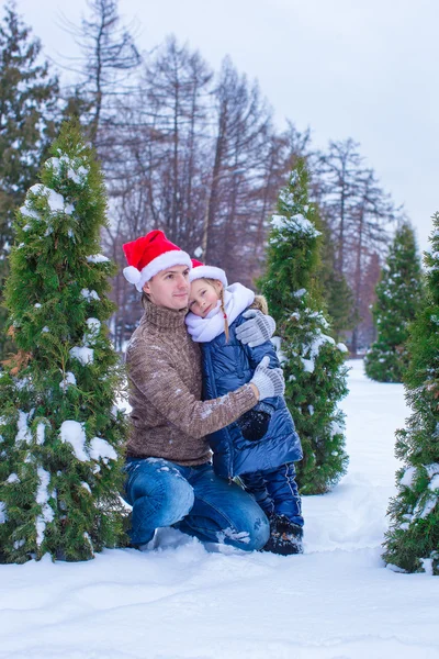 Glad familj i Santa hattar med julgran utomhus — Stockfoto