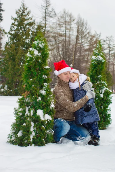 Happy family in Santa hats with christmas tree outdoor — Stock Photo, Image
