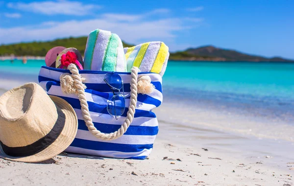 Borsa blu, cappello di paglia, infradito e asciugamano sulla spiaggia bianca — Foto Stock