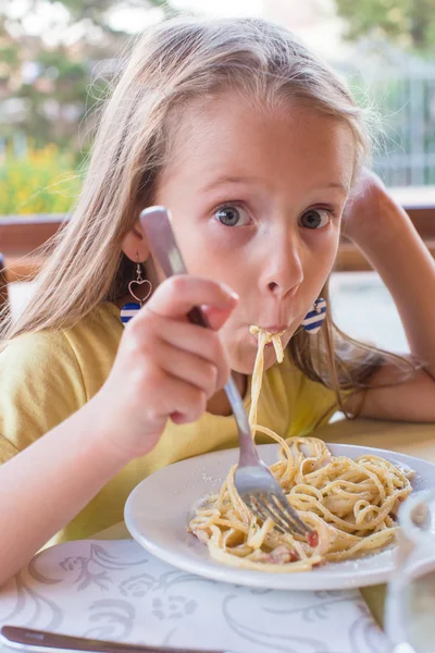 Adorable little girl eating spaghetti in outdoors restaraunt — Stock Photo, Image