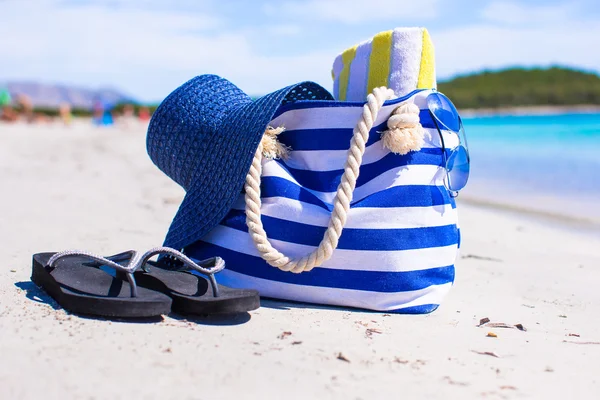 Sombrero de paja, bolsa y toalla en la playa tropical blanca —  Fotos de Stock