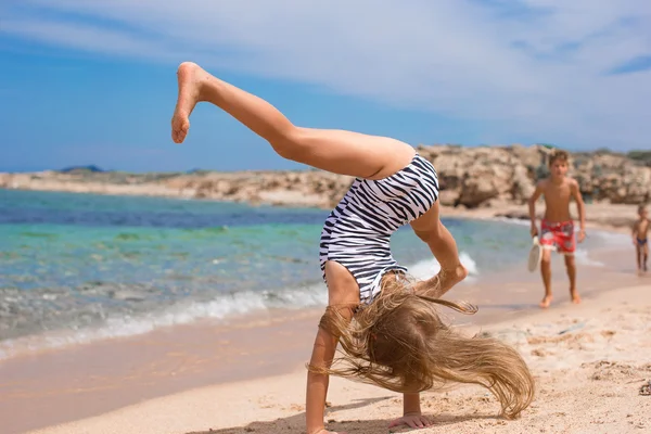 Sevimli küçük kız tropikal beyaz kumlu plaj direksiyonda yapma — Stok fotoğraf