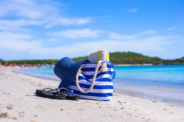 Straw hat, bag and towel on white tropical beach — Stock Photo, Image