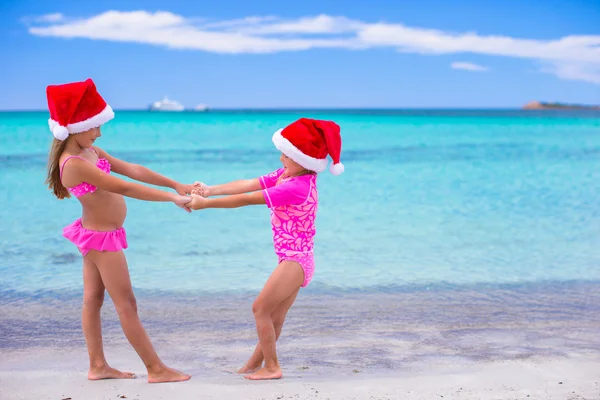 Piccole ragazze carine a Babbo Natale cappelli durante le vacanze estive — Foto Stock