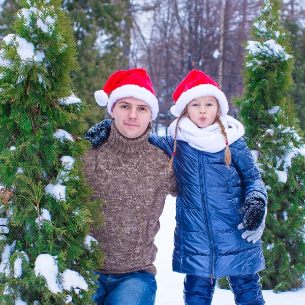 Joyeux père et enfant dans chapeaux de Noël avec arbre de Noël en plein air — Photo