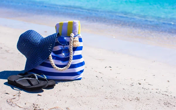 Slaměný klobouk, pytel a ručník na tropické pláži s bílým — Stock fotografie