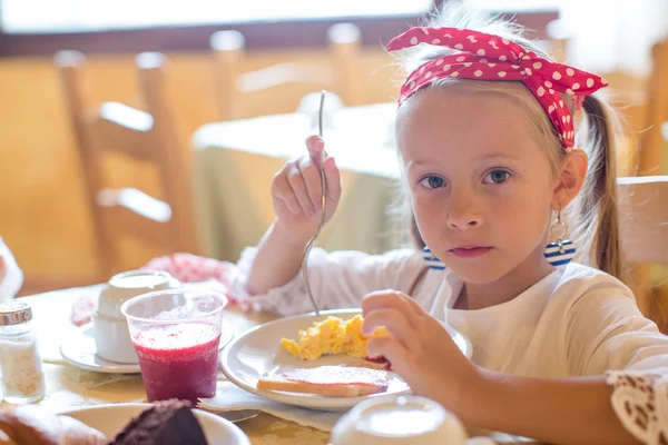 Entzückendes kleines Mädchen frühstückt im Restaurant — Stockfoto