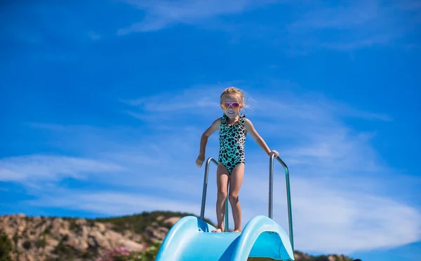 Bambina sullo scivolo d'acqua in aquapark in vacanza estiva — Foto Stock