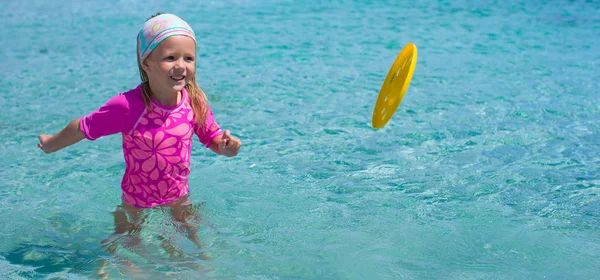 Kleines Mädchen beim Frisbee-Spielen während des Tropenurlaubs im Meer — Stockfoto