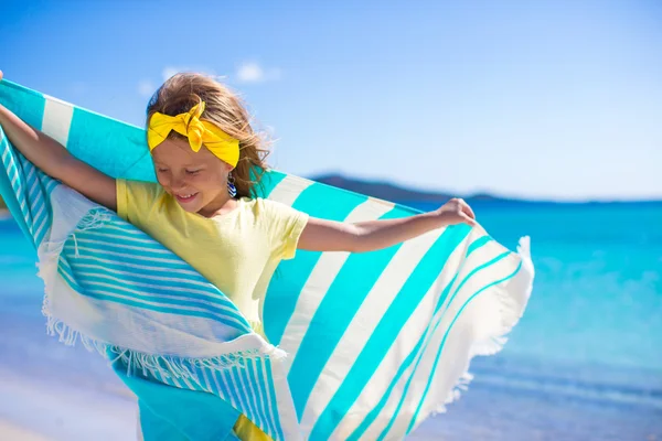 Rozkošná holčička s plážovou osušku během tropické dovolené — Stock fotografie
