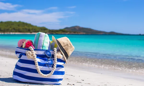 Bolso azul, sombrero de paja, chanclas y toalla en la playa blanca —  Fotos de Stock