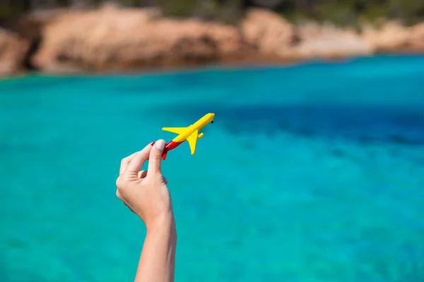 Kleines hausgemachtes Flugzeug vor dem Hintergrund des türkisfarbenen Meeres — Stockfoto