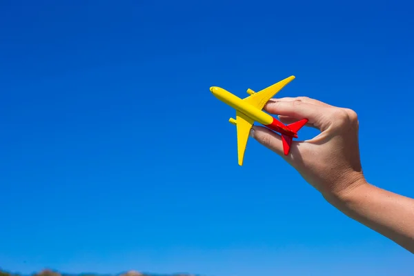 Small homemade plane in hand on background of blue sky — Stock Photo, Image