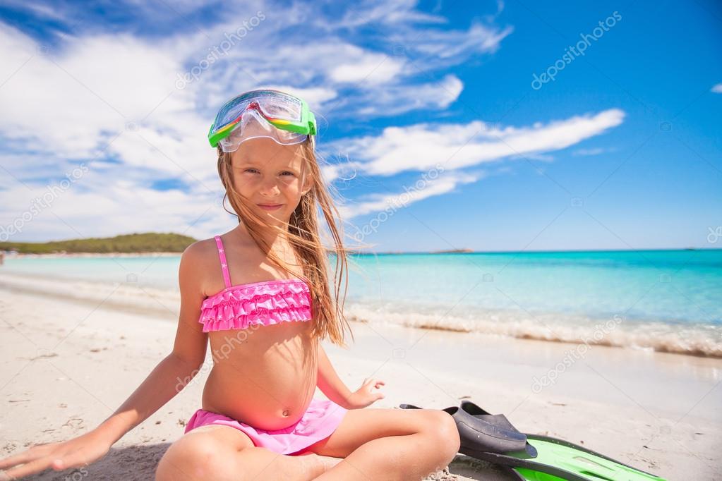 Little girl with flippers and goggles for snorkling