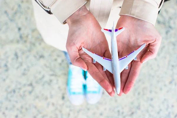 Closeup hand holding an airplane model at airport — Stock Photo, Image