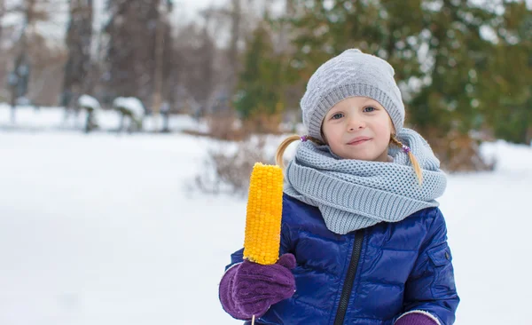Menina com milho doce no parque de inverno — Fotografia de Stock