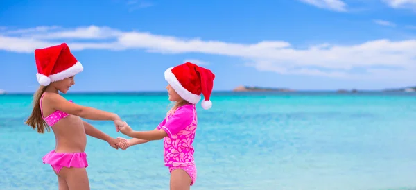 Little cute girls in Santa hats during summer vacation — Stock Photo, Image