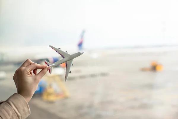Close up hand holding an airplane model at airport — Stock Photo, Image