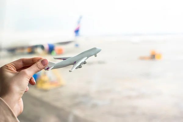 Close up hand holding an airplane model at airport — Stock Photo, Image