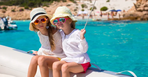 Little cute girls enjoying sailing on boat in the open sea — Stock Photo, Image