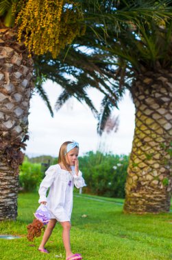 Gün batımında egzotik bir tatil köyünde sevimli küçük bir kız.