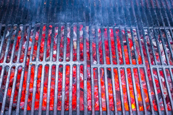 Empty black cast iron grill with hot red glowing coals — Stock Photo, Image