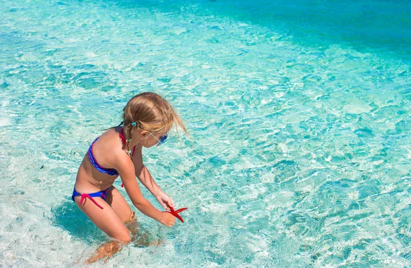 Küçük kız tropikal plaj etmek turkuaz okyanus su üzerinde eğleniyor — Stok fotoğraf