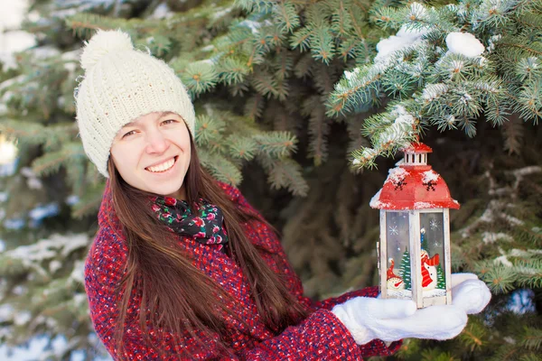 Joven hermosa mujer feliz con linterna roja de Navidad en la nieve —  Fotos de Stock