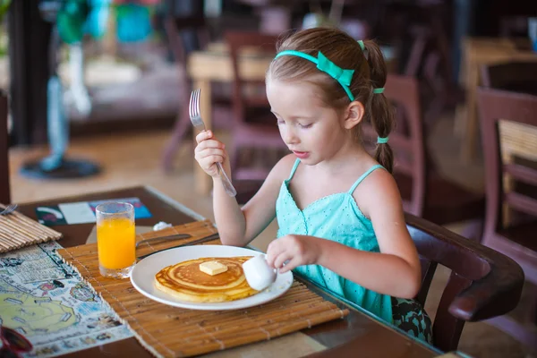 リゾートのレストランで朝食を食べたのかわいい女の子 — ストック写真