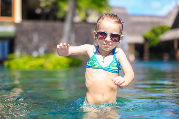 Little cute happy girl in swimming pool during summer vacation — Stock Photo, Image