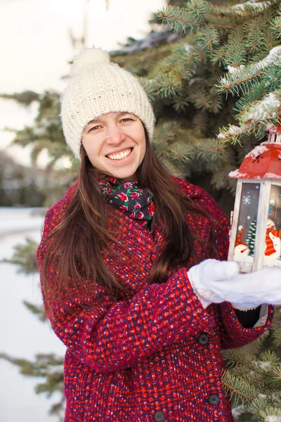 Joven hermosa mujer feliz con linterna roja de Navidad en la nieve —  Fotos de Stock