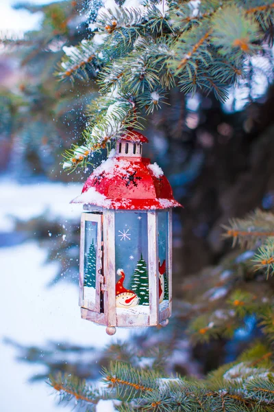 Christmas lantern with snowfall hanging on a fir branch — Stock Photo, Image