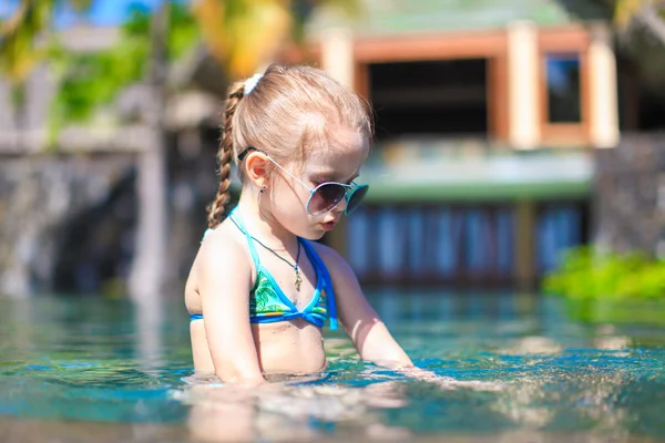 Little cute happy girl in swimming pool during summer vacation — Stock Photo, Image