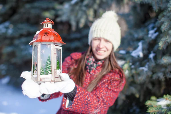 Joven mujer feliz con linterna roja de Navidad en la nieve —  Fotos de Stock