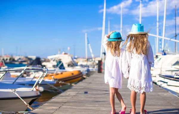 Imádnivaló kis lányok gyaloglás kikötőjében nyaralás alatt — Stock Fotó