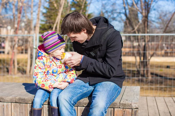 Pequena menina adorável e pai comer milho no parque — Fotografia de Stock