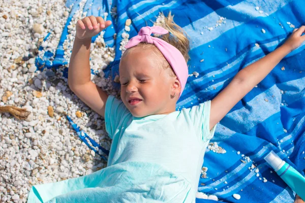 可爱的小女孩在毛巾在白色的沙滩上找到乐趣 — 图库照片