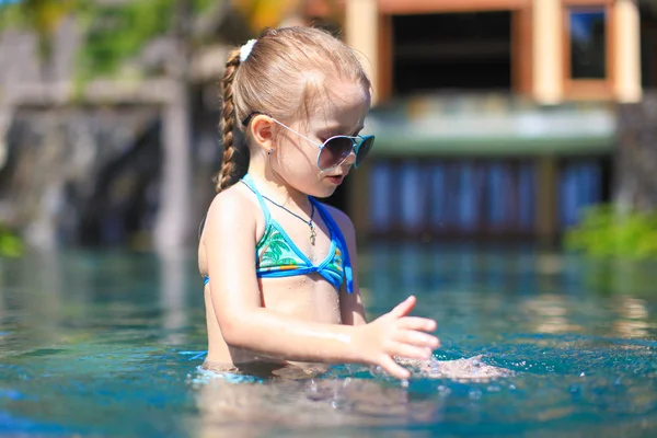 Pequena menina feliz bonito na piscina durante as férias de verão — Fotografia de Stock