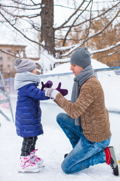 Adorable little girl and happy dad on skating rink outdoor — Stock Photo, Image