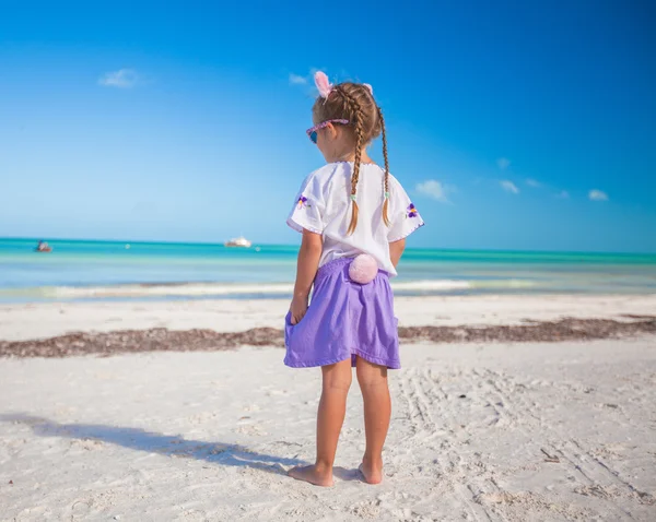可爱的小女孩，在复活节服装在异国风情的沙滩上 — 图库照片