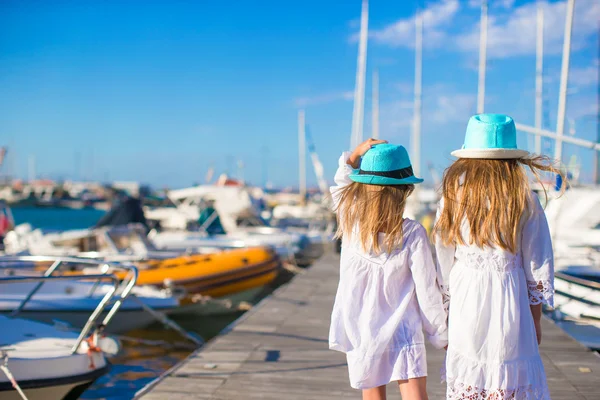 Adorable little girls walking in a port during summer vacation — Stock Photo, Image